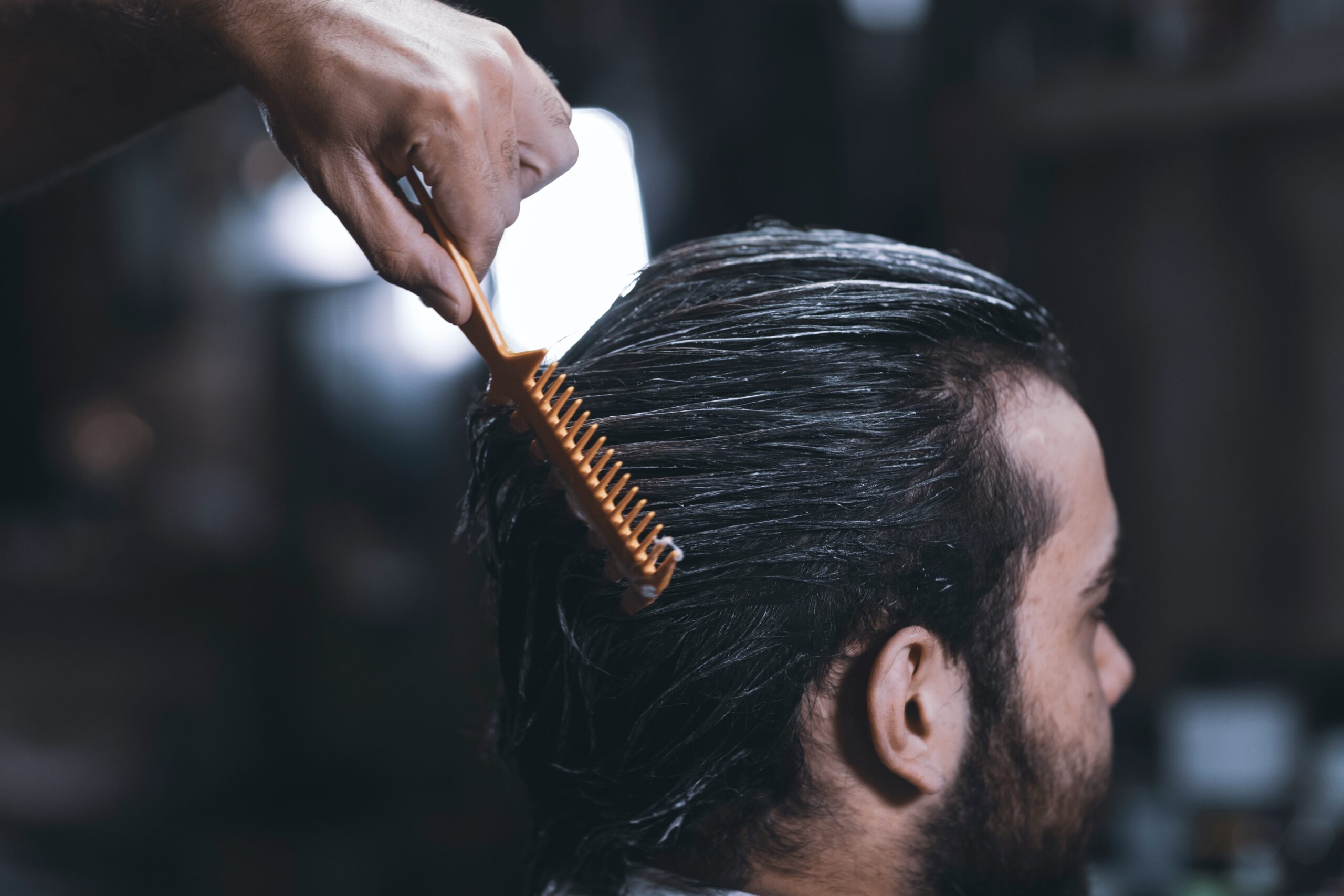 A man putting product through his hair