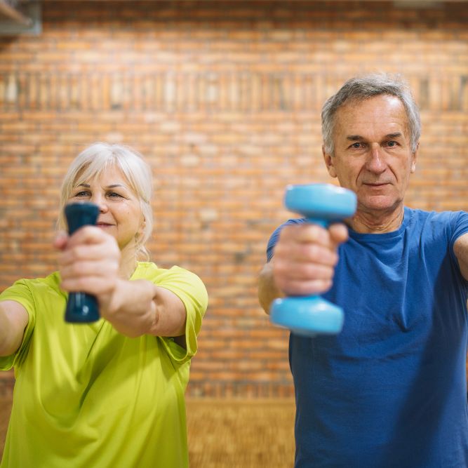 man and woman holding weights in gym
