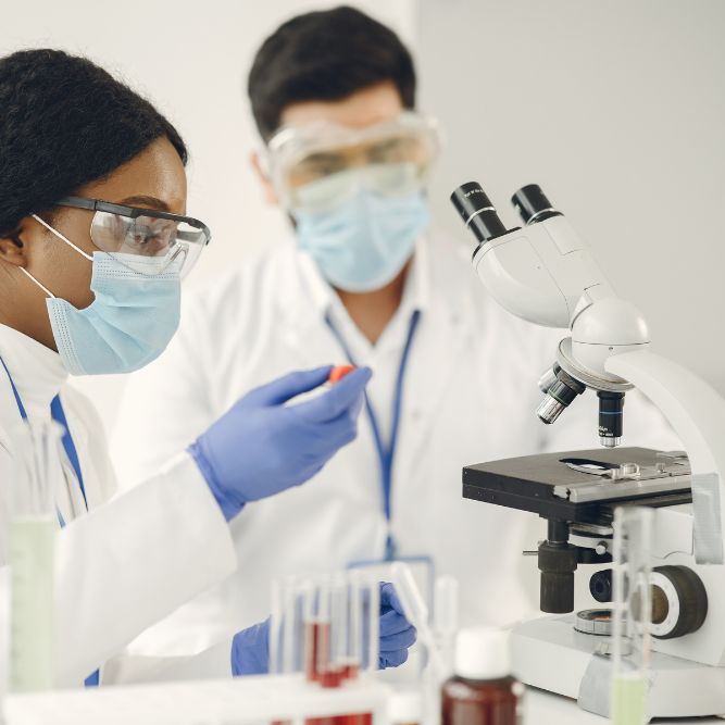 scientists analysing blood in a laboratory using a microscope