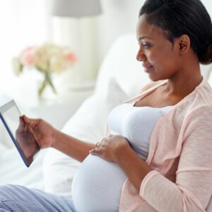 Pregnant lady looking at electronic device