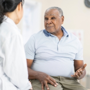 An elderly man speaking to a doctor in a clinic