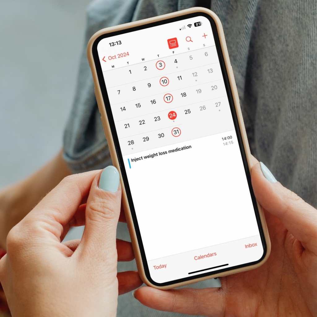 A person holding an Iphone and scheduling weight loss inections